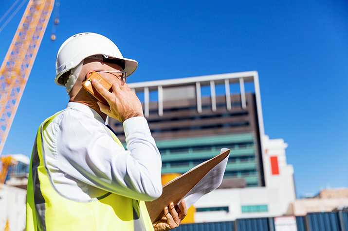 man on building site with phone