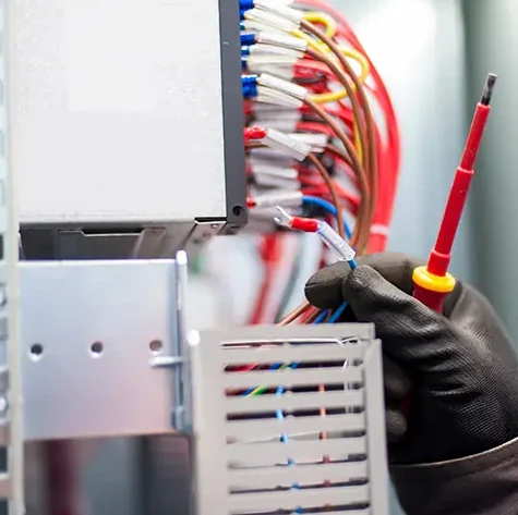 man working on wires with safety gloves and screw driver