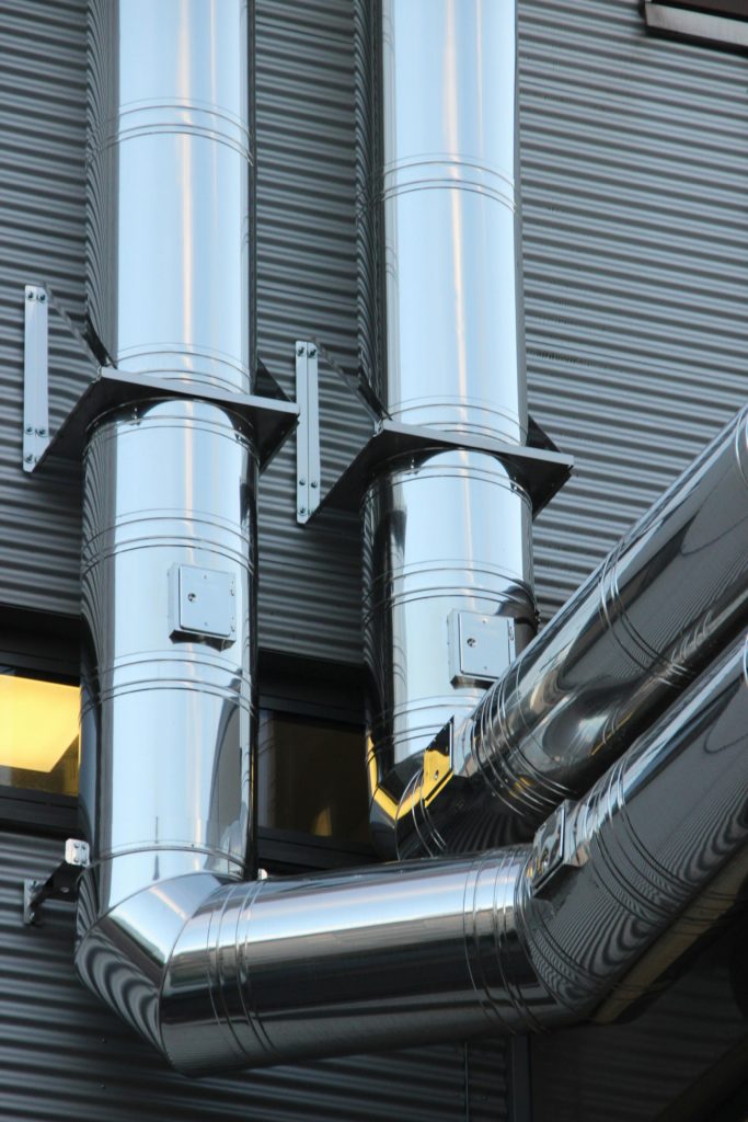 Two large metal pipes outside a facility