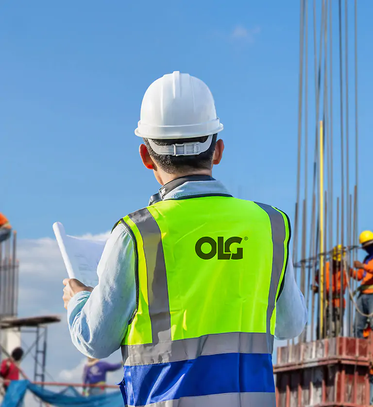 Engineer man with clipping path checking project at building sit with OLG branded high-visibility jacket on