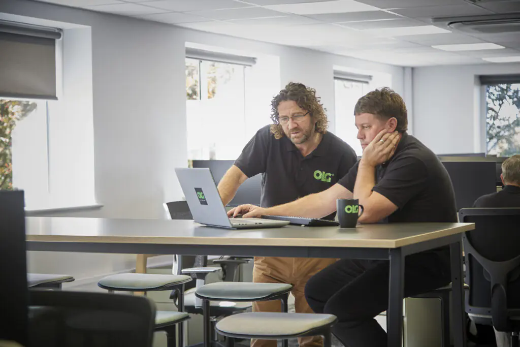 2 olg workers collaborating over a laptop