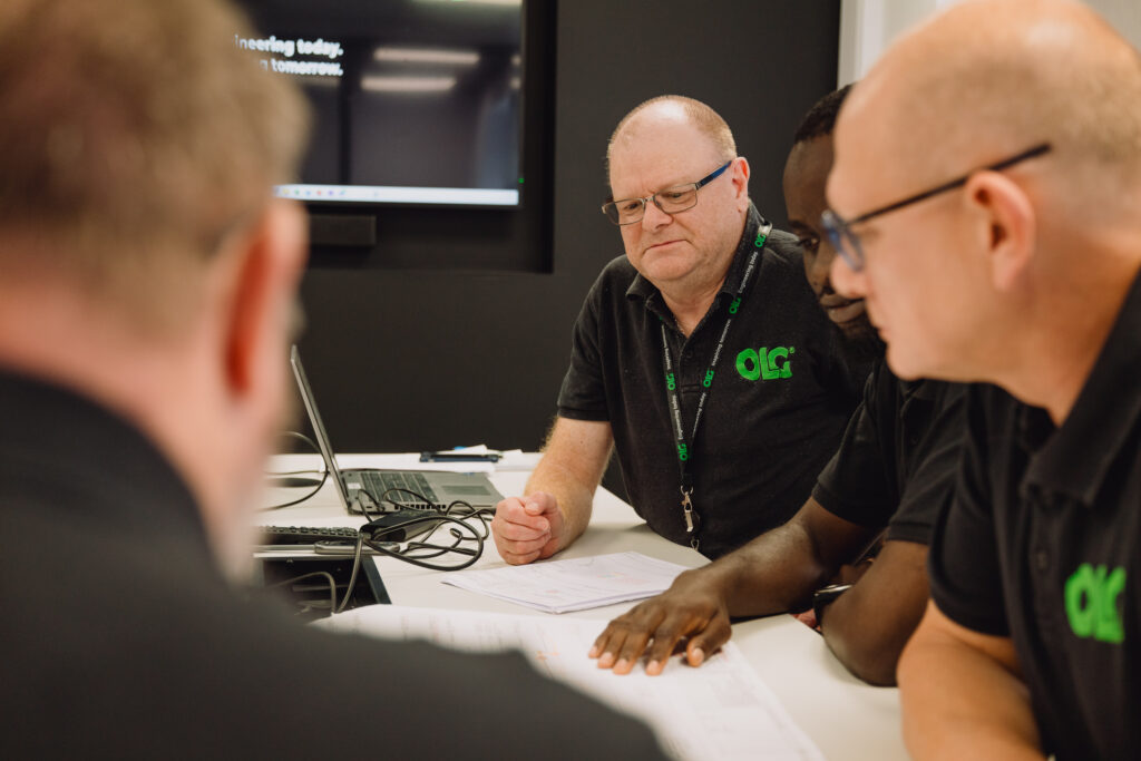 A meeting between four project managers sitting at a table.